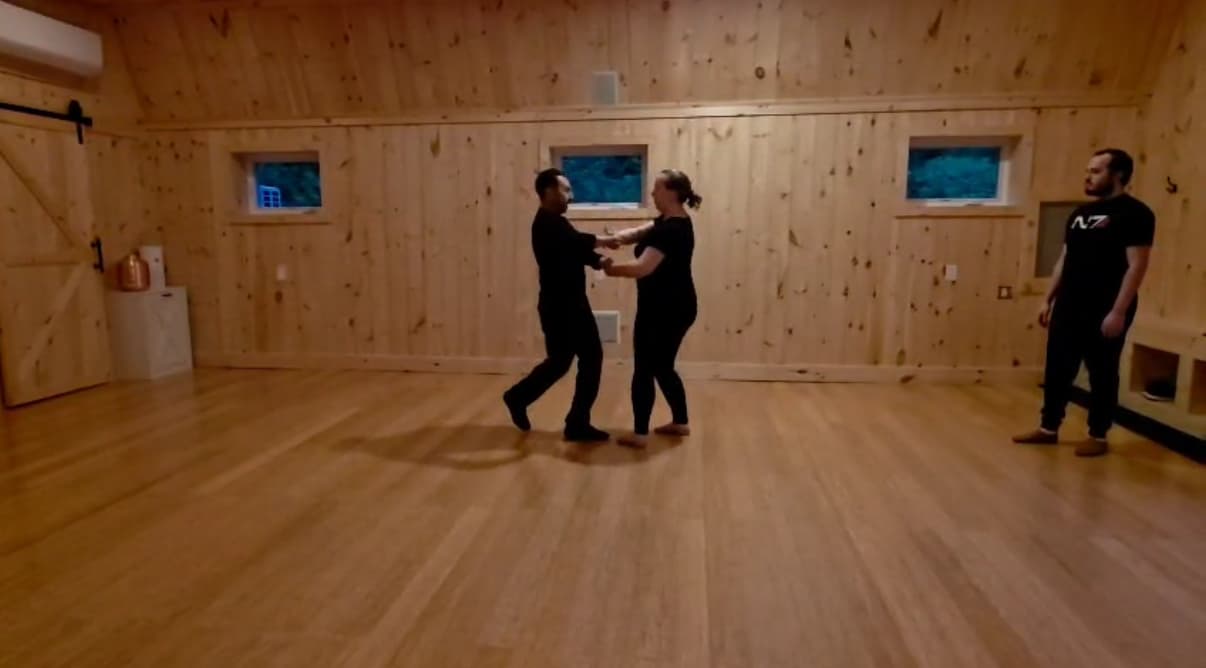 Ballroom instructor and student on a studio floor.