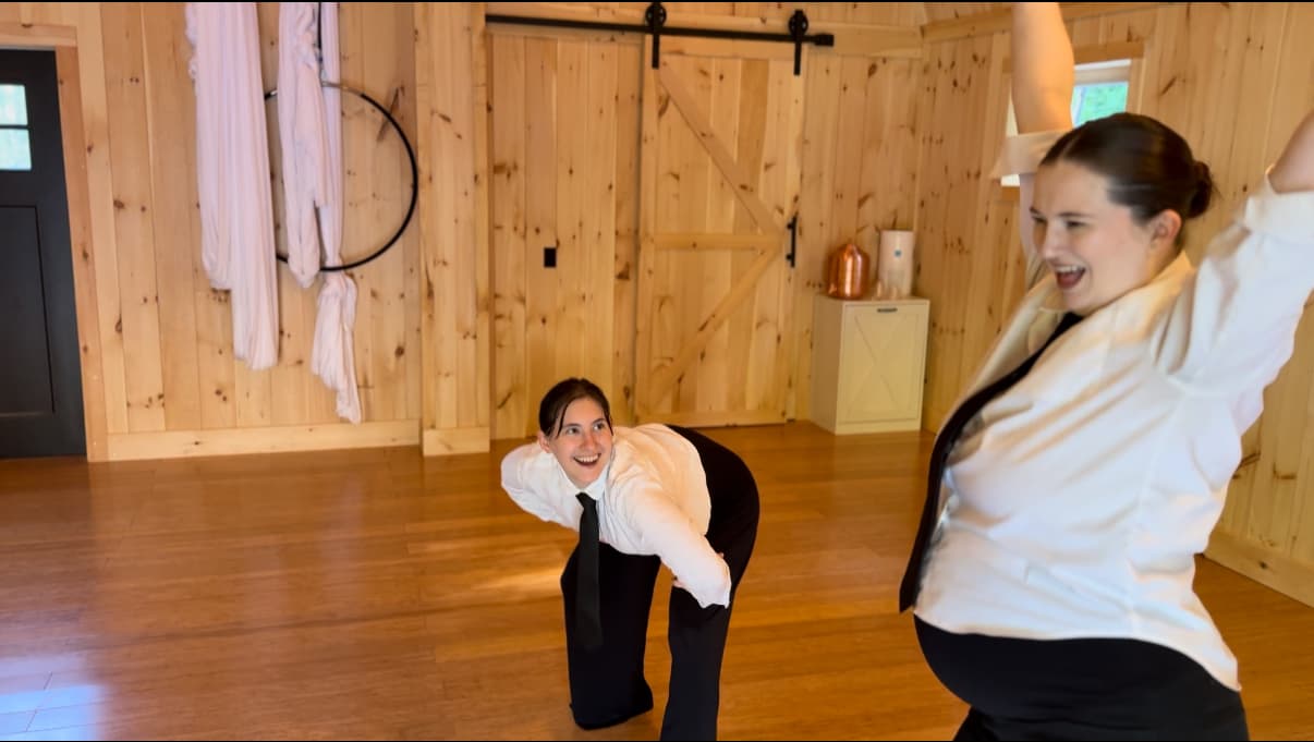 Ballroom students laughing together on the studio floor.